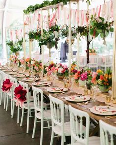 a long table is set with flowers and plates