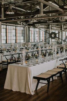 the tables are set up with white linens and clear vases on each table