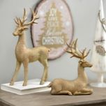 two gold deer figurines sitting on top of a table next to each other