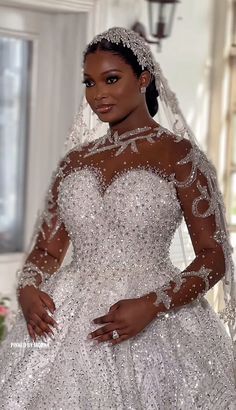 a woman in a wedding dress standing next to a window