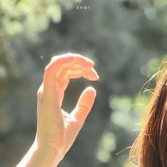 a woman holding her hand up to the sky