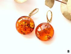 The earrings of Baltic amber in rich honey colour will not betray your expectations. It is one of the most popular colours of Baltic amber.  These massive, elegant, sophistically sparkling earrings with a spangle inside are an irresistible piece of jewellery that you will love wearing every day. It is a genuine, natural and unique piece of jewellery created by nature, so you will feel special on every occasion. Delight yourself or your loved one with a little miracle from nature.  EARRINGS A Ear Orange Baltic Amber Round Jewelry, Handmade Orange Earrings For Formal Occasions, Round Tortoiseshell Earrings For Gift, Tortoiseshell Round Earrings For Gift, Honey Color, Baltic Amber Jewelry, Clear Earrings, Color Earrings, Amber Earrings