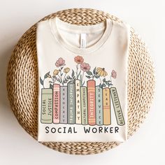 a t - shirt that says social worker with books and flowers on it in front of a wicker basket