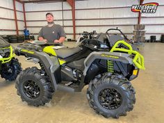 a man standing next to an atv in a garage