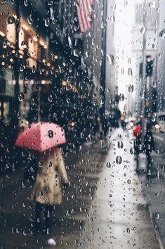 a person walking down the street in the rain with an umbrella