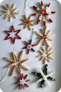 six wooden stars are arranged on a white surface with string and beads hanging from them