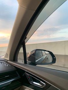 a car's side view mirror is seen from inside the driver's seat