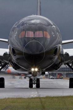 a large jetliner sitting on top of an airport tarmac with its lights on