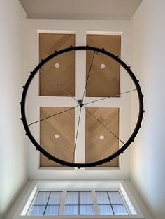 a large clock mounted to the side of a wall in a room with wooden floors