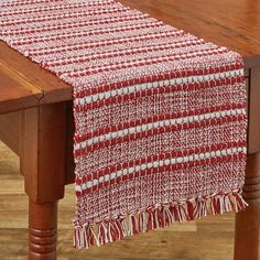 a red and white table runner on top of a wooden table