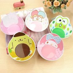 hello kitty paper plates on a table with flowers in the vase and other decorative items