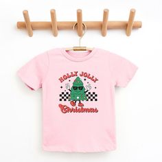 Looking for a cute tee for your kids? We have the perfect Holly Jolly Christmas Tree graphic tee addition to their closet! Also available in toddler tees. Kids Christmas Shirts, Toddler Christmas Tree, Christmas Tree Graphic, Christmas Shirts For Kids, Holly Wreath, Christmas Collage, Holly Jolly Christmas, Santa's Little Helper, Tree Graphic