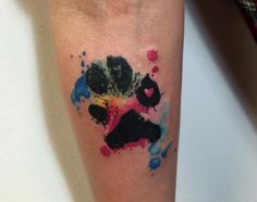 a colorful ink splattered on the leg of a person's left arm