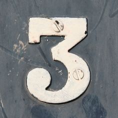 the number three is written in white metal