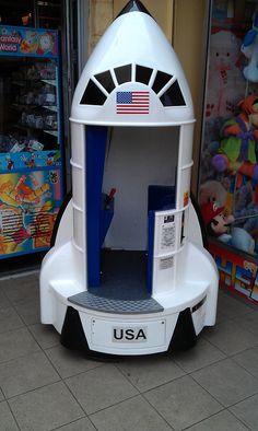 a white and blue space shuttle type device on display in front of a toy store