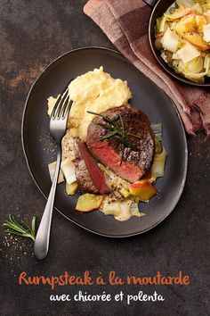 a black plate topped with meat and potatoes next to a bowl of mashed potatoes