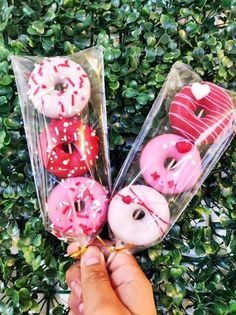 a person is holding some doughnuts with sprinkles in their hands