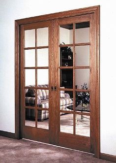 a living room filled with furniture and large mirrors on the wall above it's doors