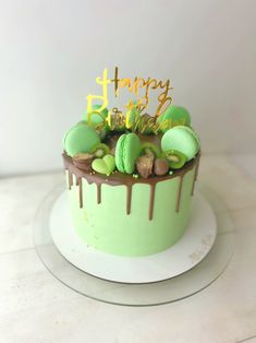 a birthday cake with green frosting and gold letters