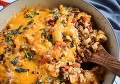 a skillet filled with pasta and meat covered in cheese