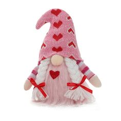 a pink and white knitted gnome with hearts on it's head, sitting in front of a white background