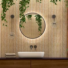 the bathroom is decorated with bamboo and has a round mirror above the sink, along with hanging plants