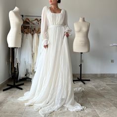 a woman standing in front of some mannequins wearing a white wedding dress