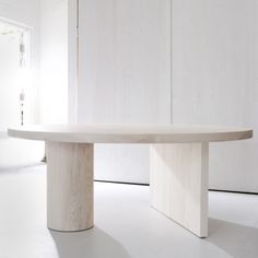 a white table sitting in the middle of a room next to a wall and floor