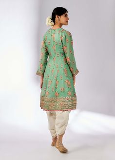 This pretty ensemble in floral jaal, combines gota and dori buttis with an intricate border embroidery. The short kurta with a dhoti embroidered in sequins and gold thread, adds a feminine grace. Festive Pista Green Palazzo Set With Floral Embroidery, Festive Pista Green Floral Embroidered Palazzo Set, Pista Green Straight Kurta With Floral Embroidery, Pista Green Chanderi Kurta With Floral Embroidery, Eid Green Sherwani With Floral Embroidery, Festive Cotton Silk Sherwani With Gota Work, Bollywood Style Pista Green Palazzo Set With Floral Embroidery, Pista Green Sharara With Floral Embroidery, Transitional Traditional Wear With Floral Embroidery In Pista Green