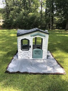 a small white dog house in the grass