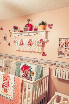 a baby's room with pink walls and pictures on the wall