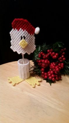 a knitted bird is sitting next to a christmas decoration