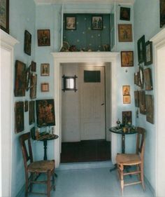 an entry way with chairs and pictures on the wall