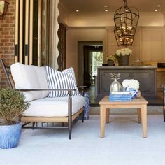 a living room filled with furniture next to a brick wall