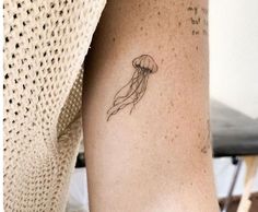 a small jellyfish tattoo on the arm