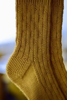 a pair of yellow socks hanging from a clothes line with the words new pattern on it