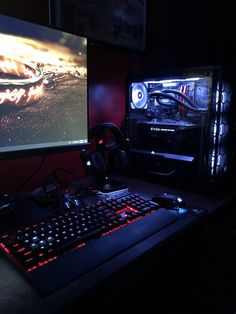 a computer desk with two monitors and a keyboard in front of the monitor is lit up by red lights