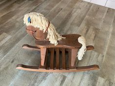 a wooden rocking horse sitting on top of a hard wood floor