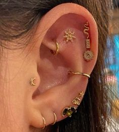 an ear with three different types of piercings on it's sides and one is in the shape of a star