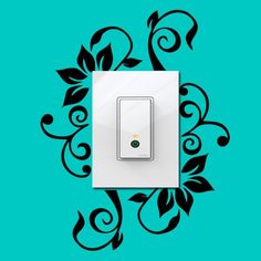 a white light switch sitting on top of a blue wall next to a green plant