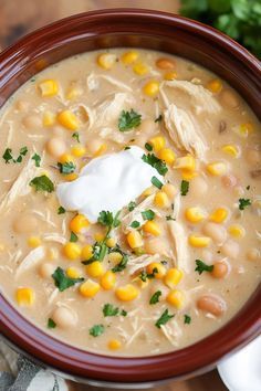 a bowl of soup with corn and sour cream