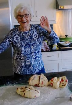 an older woman standing in front of some cookies