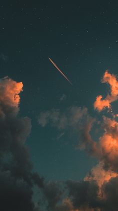 an airplane is flying in the sky with clouds and stars around it at night time