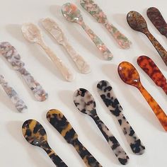 an assortment of spoons are arranged on a white surface with different patterns and sizes