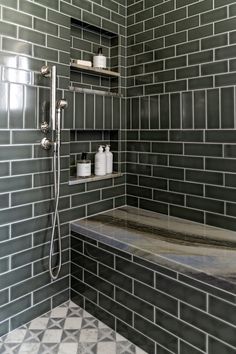 a tiled shower with shelves and soap dispensers