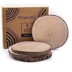 four wood slices sitting next to each other in front of a cardboard box with the word project52 on it