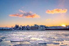 the sun is setting over an icy city