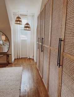 a bedroom with wooden closets and white curtains