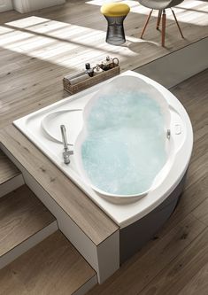 a large bath tub sitting on top of a wooden floor