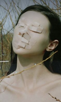 a woman with her face cut out to look like a piece of paper on her face